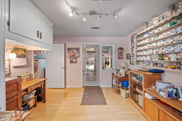 2940 Felstet Ln, Redding, CA 96001 - kitchen featuring light wood-style floors, open shelves, washer / clothes dryer, and track lighting