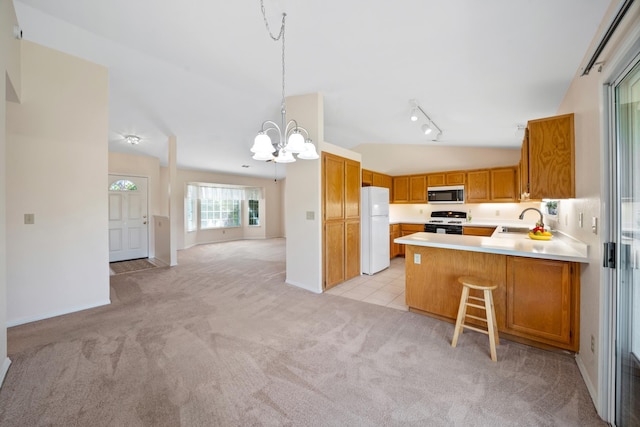 1626 French Lace Ln, Redding, CA 96003 - kitchen featuring freestanding refrigerator, stainless steel microwave, gas range oven, a chandelier, and light carpet