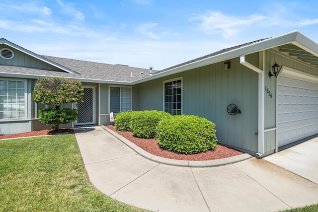 1626 French Lace Ln, Redding, CA 96003 - view of exterior entry featuring roof with shingles, a garage, concrete driveway, and a lawn