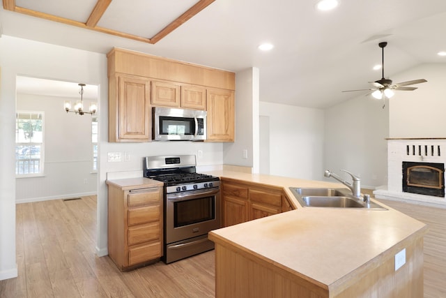 13360 Oak Run Rd, Oak Run, CA 96069 - kitchen featuring appliances with stainless steel finishes, a sink, light brown cabinets, light wood finished floors, and a fireplace