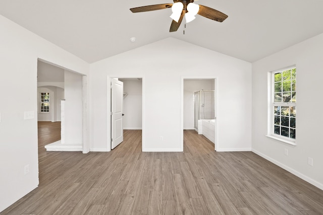 13360 Oak Run Rd, Oak Run, CA 96069 - unfurnished bedroom featuring a walk in closet, arched walkways, light wood-type flooring, lofted ceiling, and baseboards