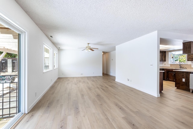 3640 Oro St, Redding, CA 96001 - unfurnished living room with a sink, a textured ceiling, light wood finished floors, ceiling fan, and baseboards