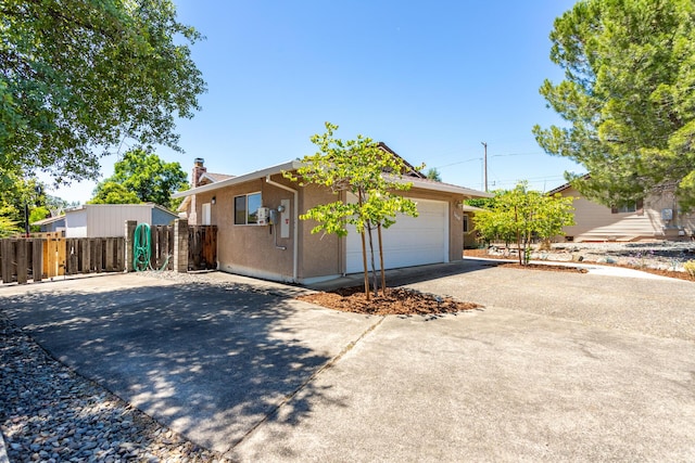 3640 Oro St, Redding, CA 96001 - view of front facade with driveway, a chimney, an attached garage, and stucco siding