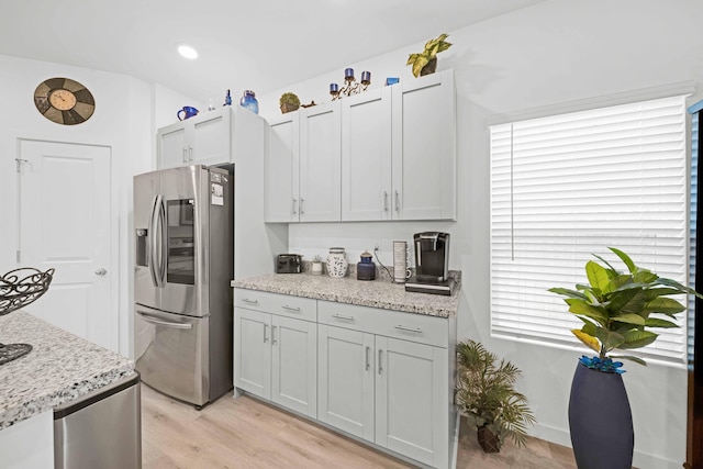 2764 Austere Ave, Redding, CA 96003 - kitchen featuring stainless steel refrigerator with ice dispenser, light wood-style floors, and light stone countertops