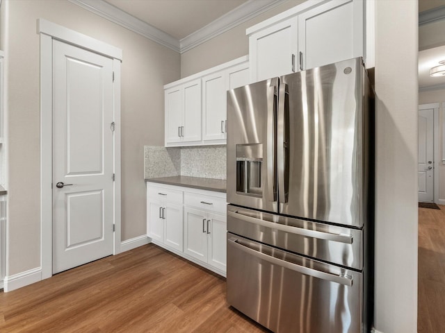 2830 Calaveras Ct, Redding, CA 96002 - kitchen with stainless steel fridge with ice dispenser, wood finished floors, crown molding, white cabinetry, and backsplash