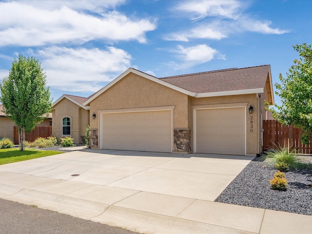 2830 Calaveras Ct, Redding, CA 96002 - ranch-style house featuring a garage, stucco siding, driveway, and stone siding