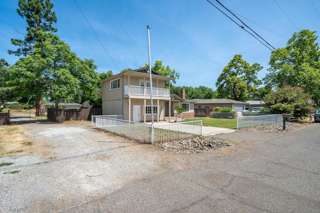 5101 Bidwell Rd, Redding, CA 96001 - view of front of property with a balcony, a fenced front yard, driveway, and a gate