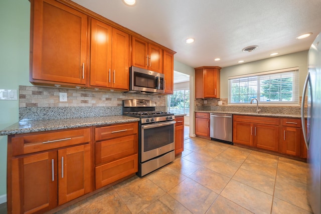 5101 Bidwell Rd, Redding, CA 96001 - kitchen featuring stainless steel appliances, brown cabinets, backsplash, light stone countertops, and recessed lighting
