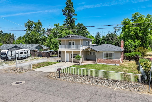 5101 Bidwell Rd, Redding, CA 96001 - view of front of property with a balcony, brick siding, a porch, a chimney, and driveway