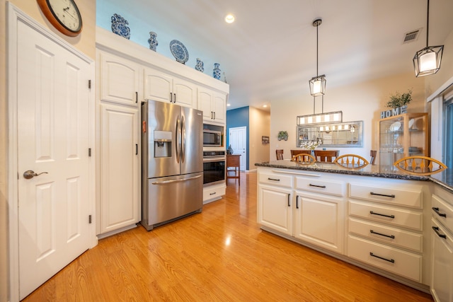 1030 Tulare Ct, Redding, CA 96003 - kitchen featuring appliances with stainless steel finishes, light wood-style floors, recessed lighting, white cabinets, and dark stone countertops