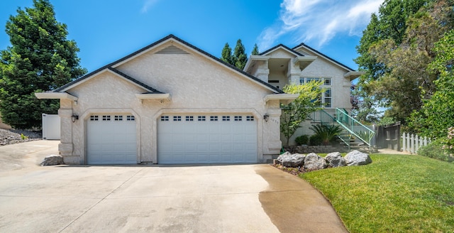 1030 Tulare Ct, Redding, CA 96003 - view of front of home featuring stucco siding, an attached garage, driveway, and stairway