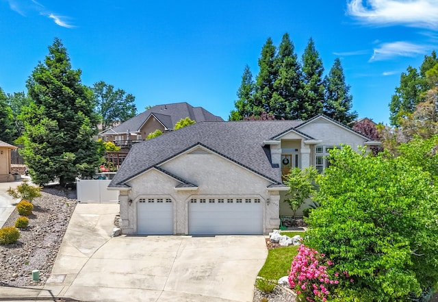 1030 Tulare Ct, Redding, CA 96003 - traditional-style house featuring an attached garage, driveway, stucco siding, and roof with shingles