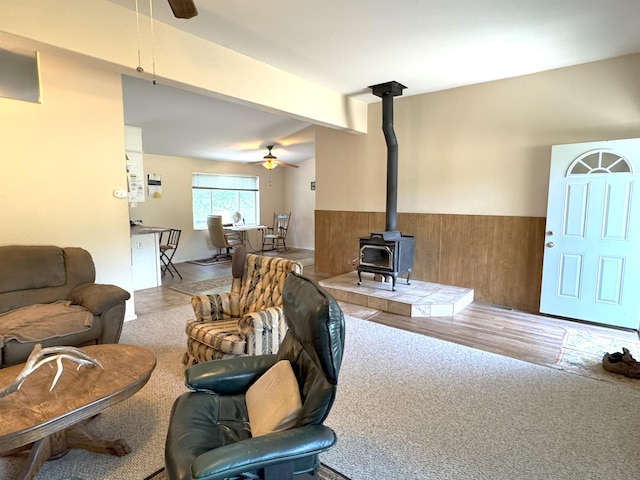 29093 Day Rd, Mcarthur, CA 96056 - living area with a ceiling fan, a wood stove, wainscoting, and beam ceiling