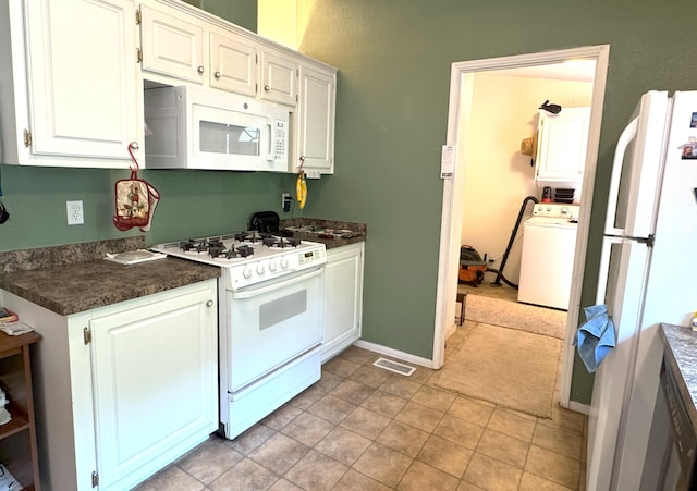 29093 Day Rd, Mcarthur, CA 96056 - kitchen featuring white appliances, washer / clothes dryer, dark countertops, white cabinetry, and baseboards