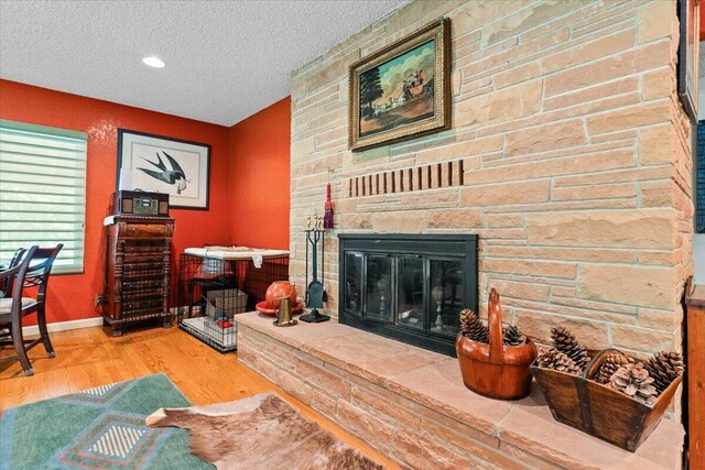 3141 Meadow Oak Dr, Cottonwood, CA 96022 - living room with wood finished floors, a textured ceiling, a fireplace, and baseboards