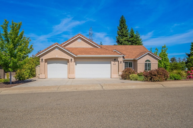 1005 Albion Ave, Redding, CA 96003 - view of front of property with stucco siding, an attached garage, a tile roof, and concrete driveway