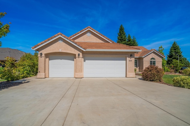1005 Albion Ave, Redding, CA 96003 - ranch-style house featuring stucco siding, driveway, a garage, and a tiled roof