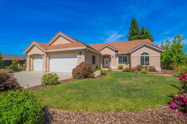 1005 Albion Ave, Redding, CA 96003 - ranch-style home with a tile roof, stucco siding, an attached garage, and driveway