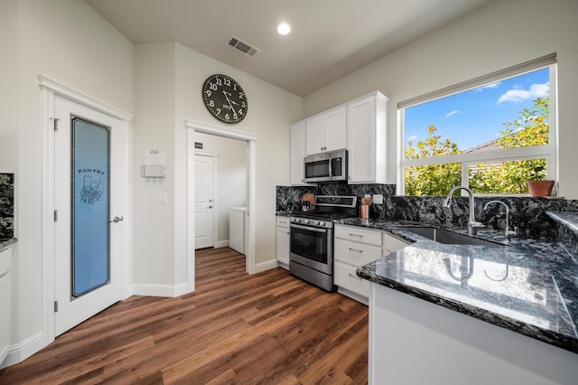 1005 Albion Ave, Redding, CA 96003 - kitchen with appliances with stainless steel finishes, a sink, dark wood-style flooring, white cabinetry, and dark stone countertops