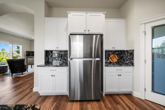 1005 Albion Ave, Redding, CA 96003 - kitchen featuring freestanding refrigerator, dark stone counters, dark wood-type flooring, and healthy amount of natural light