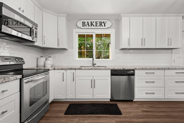 1666 Willis St, Redding, CA 96001 - kitchen featuring stainless steel appliances, white cabinetry, tasteful backsplash, and light stone countertops