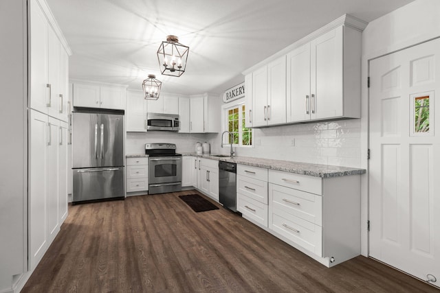 1666 Willis St, Redding, CA 96001 - kitchen featuring stainless steel appliances, decorative backsplash, dark wood-style flooring, and white cabinets