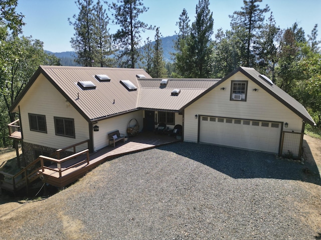 261 Salt Flat Rd, Lewiston, CA 96052 - view of front of home with gravel driveway, a garage, a metal roof, and a deck with mountain view