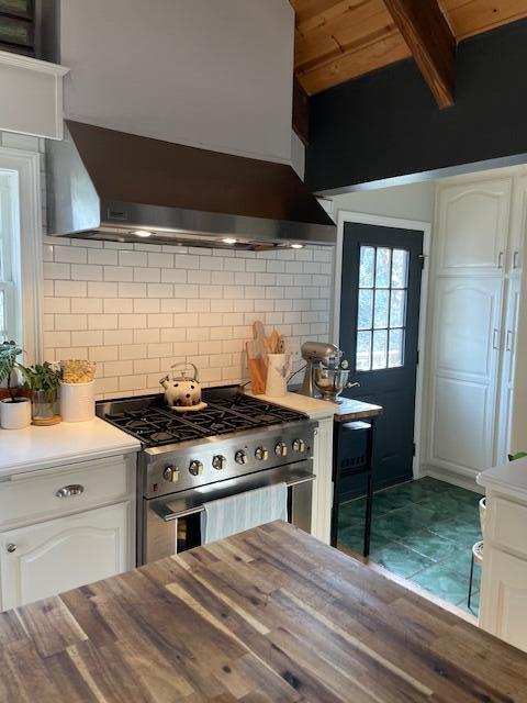 261 Salt Flat Rd, Lewiston, CA 96052 - kitchen featuring stainless steel gas range oven, wall chimney range hood, white cabinets, decorative backsplash, and wooden ceiling