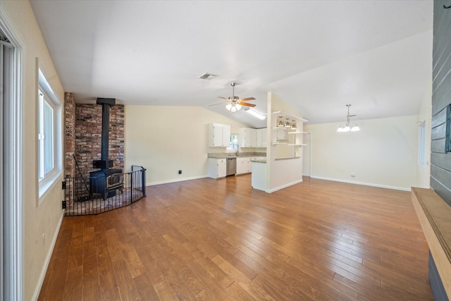 466 Tourmaline Way, Redding, CA 96003 - unfurnished living room with a wood stove, ceiling fan, wood finished floors, vaulted ceiling, and a chandelier