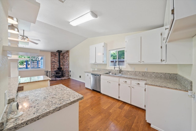 466 Tourmaline Way, Redding, CA 96003 - kitchen featuring stainless steel dishwasher, a wood stove, lofted ceiling, ceiling fan, and white cabinetry