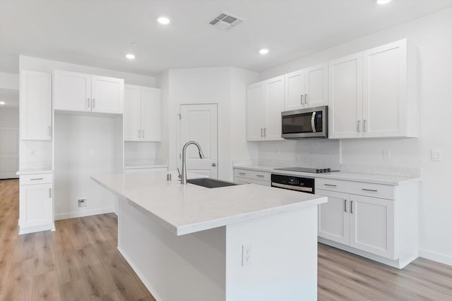 4206 Acadia Pl, Redding, CA 96001 - kitchen with a sink, stainless steel appliances, light wood finished floors, a center island with sink, and recessed lighting