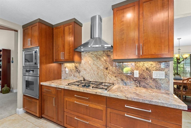 2364 La Madre Ct, Redding, CA 96002 - kitchen featuring wall chimney range hood, stainless steel appliances, brown cabinetry, and a textured ceiling