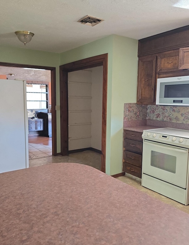 846 Ridge Rd, Redding, CA 96003 - kitchen featuring electric range, dark brown cabinets, a textured ceiling, and light countertops