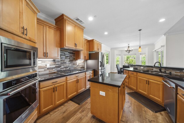 4648 Kilkee Dr, Redding, CA 96001 - kitchen featuring stainless steel appliances, a sink, ornamental molding, backsplash, and dark wood finished floors