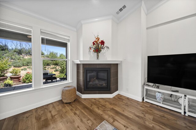4648 Kilkee Dr, Redding, CA 96001 - unfurnished living room featuring ornamental molding, a tiled fireplace, baseboards, and wood finished floors