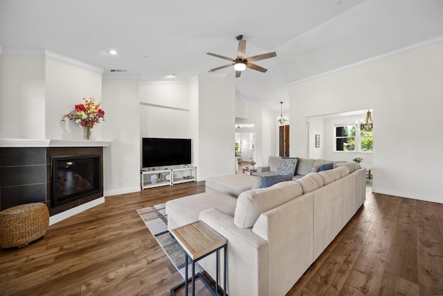 4648 Kilkee Dr, Redding, CA 96001 - living area with ornamental molding, a tiled fireplace, dark wood-style flooring, ceiling fan, and vaulted ceiling