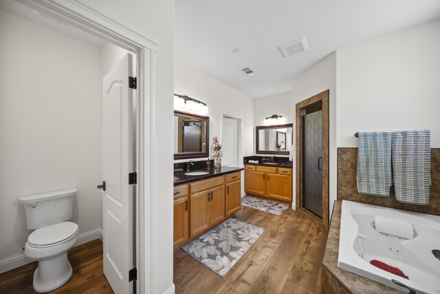 4648 Kilkee Dr, Redding, CA 96001 - bathroom with vanity, wood finished floors, a stall shower, a whirlpool tub, and toilet