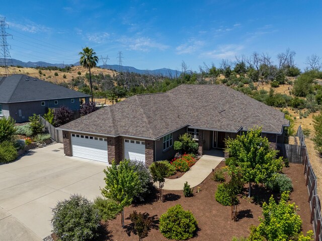 4648 Kilkee Dr, Redding, CA 96001 - ranch-style home with an attached garage, driveway, a mountain view, and roof with shingles
