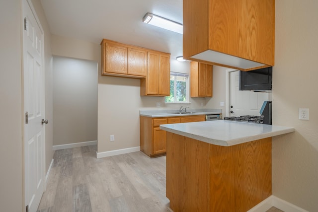 5867 Bell Rd, Redding, CA 96001 - kitchen with light wood-style floors, a sink, a peninsula, light countertops, and stove