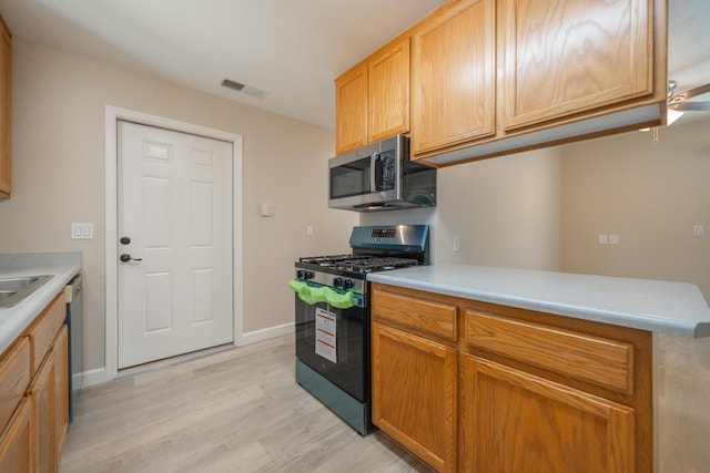 5867 Bell Rd, Redding, CA 96001 - kitchen with appliances with stainless steel finishes, light wood-style flooring, light countertops, and baseboards