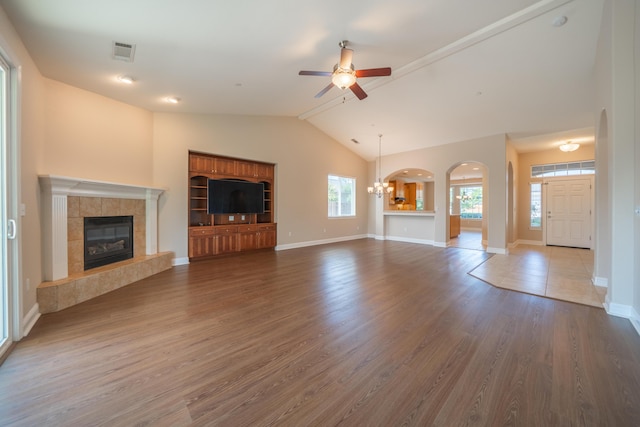 3337 Old Lantern Dr, Redding, CA 96003 - unfurnished living room with ceiling fan, a tile fireplace, arched walkways, lofted ceiling, and wood finished floors