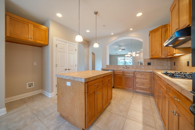 3337 Old Lantern Dr, Redding, CA 96003 - kitchen featuring under cabinet range hood, arched walkways, gas cooktop, light countertops, and recessed lighting