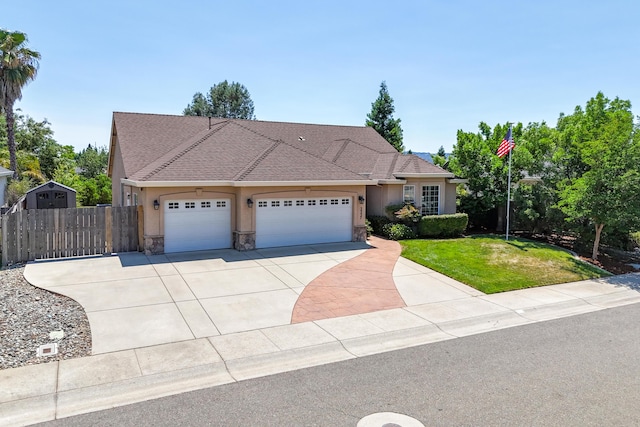 3337 Old Lantern Dr, Redding, CA 96003 - view of front facade featuring stucco siding, an attached garage, driveway, and stone siding