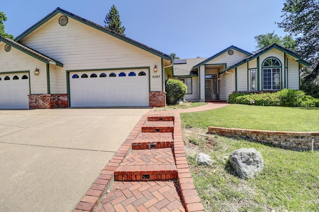 3097 Butterfly Ln, Shasta Lake, CA 96019 - ranch-style house featuring a garage, concrete driveway, a front lawn, and roof mounted solar panels