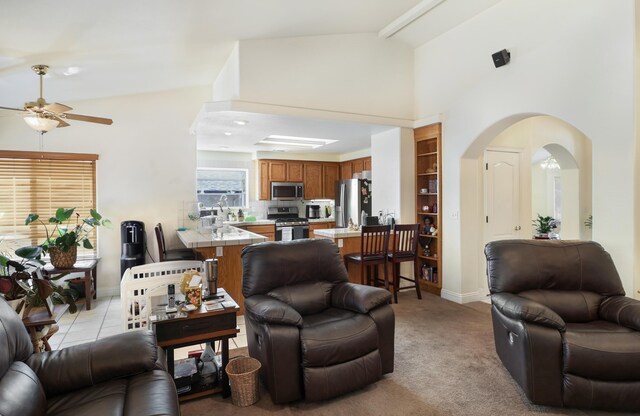 3097 Butterfly Ln, Shasta Lake, CA 96019 - living area featuring a ceiling fan, high vaulted ceiling, arched walkways, baseboards, and light carpet