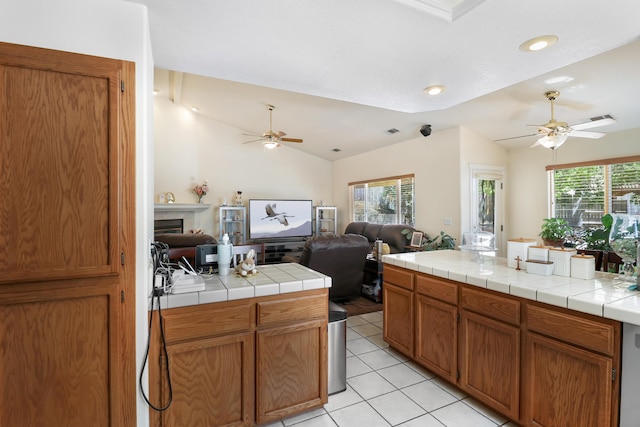 3097 Butterfly Ln, Shasta Lake, CA 96019 - kitchen with ceiling fan, vaulted ceiling, open floor plan, light tile patterned flooring, and brown cabinets
