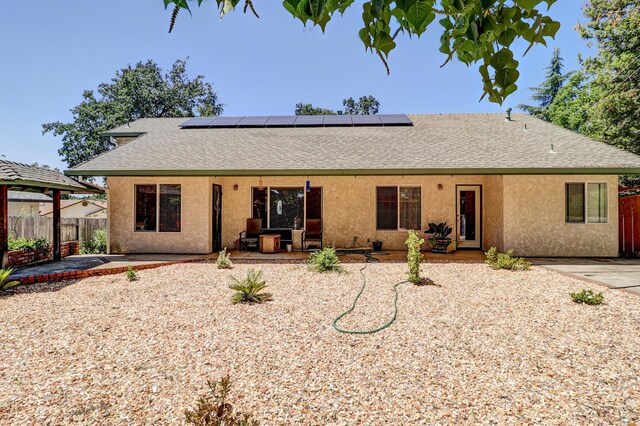 3097 Butterfly Ln, Shasta Lake, CA 96019 - view of front of house featuring a shingled roof, roof mounted solar panels, stucco siding, and a patio area