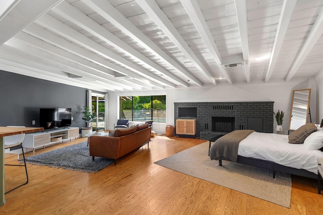 2180 Oak Ridge Dr, Redding, CA 96001 - bedroom featuring beamed ceiling, wood finished floors, and a fireplace