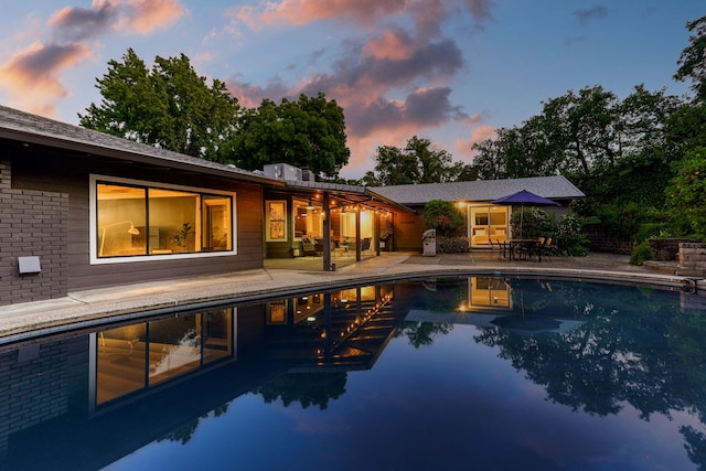 2180 Oak Ridge Dr, Redding, CA 96001 - pool at dusk with a patio area, an outdoor pool, and grilling area