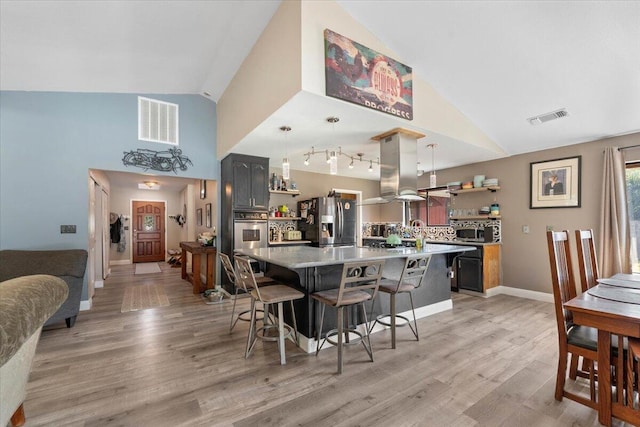 2025 El Verano St, Redding, CA 96002 - kitchen featuring open shelves, stainless steel appliances, island range hood, a kitchen breakfast bar, and light countertops